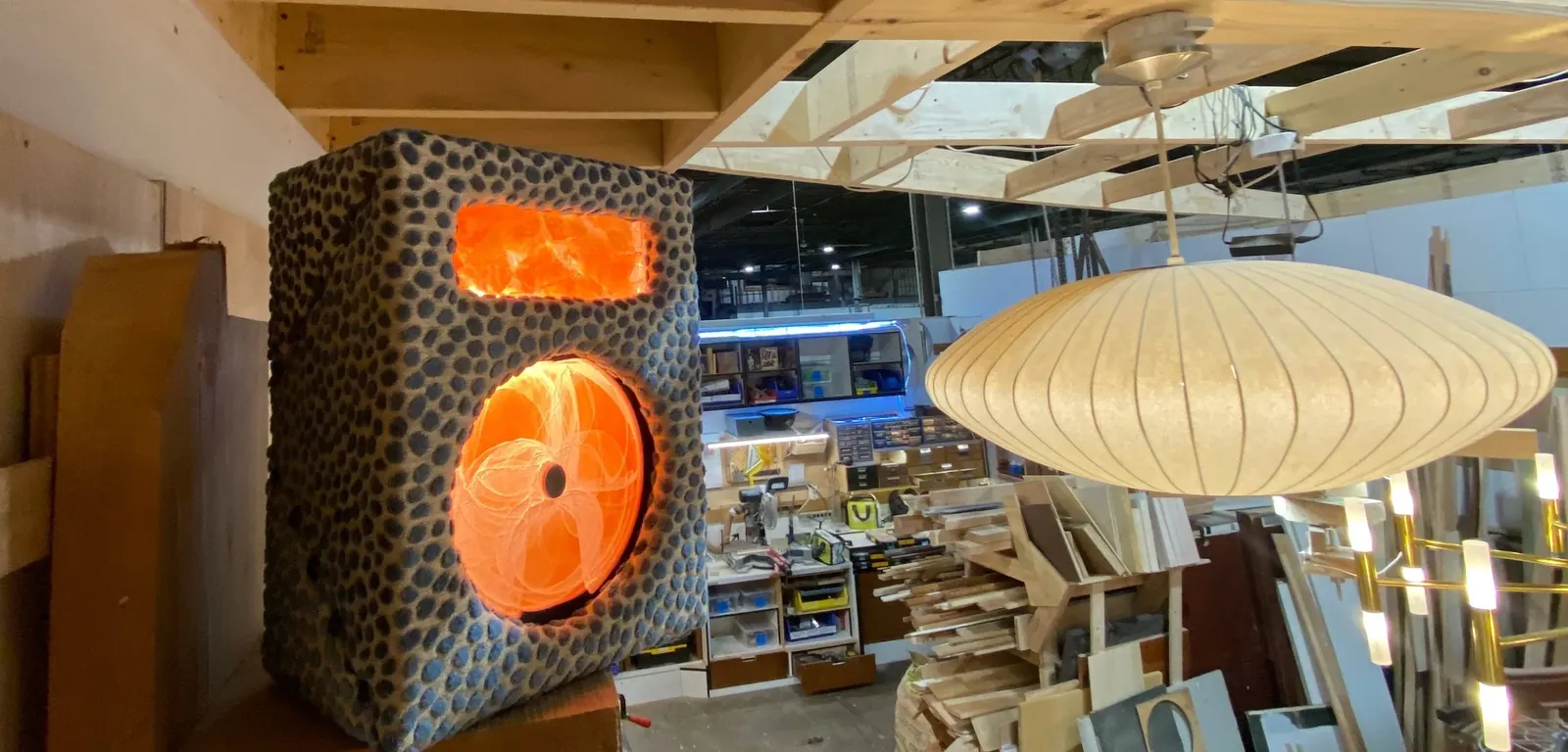 Pebbled speaker cabinet with an orange lighted cone in the shop
