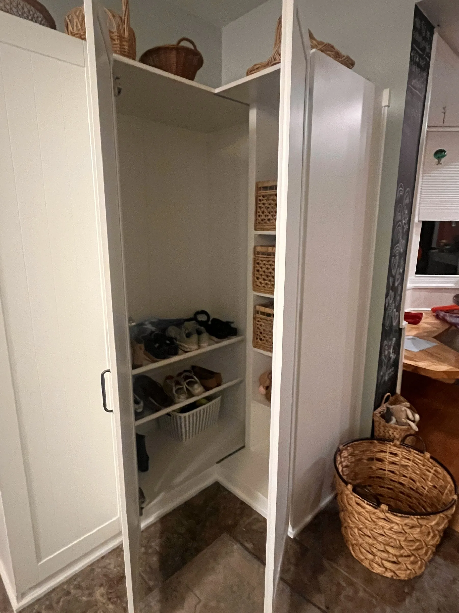 Corner cabinet doors open: adjustable shelves, woven bins and shoe storage