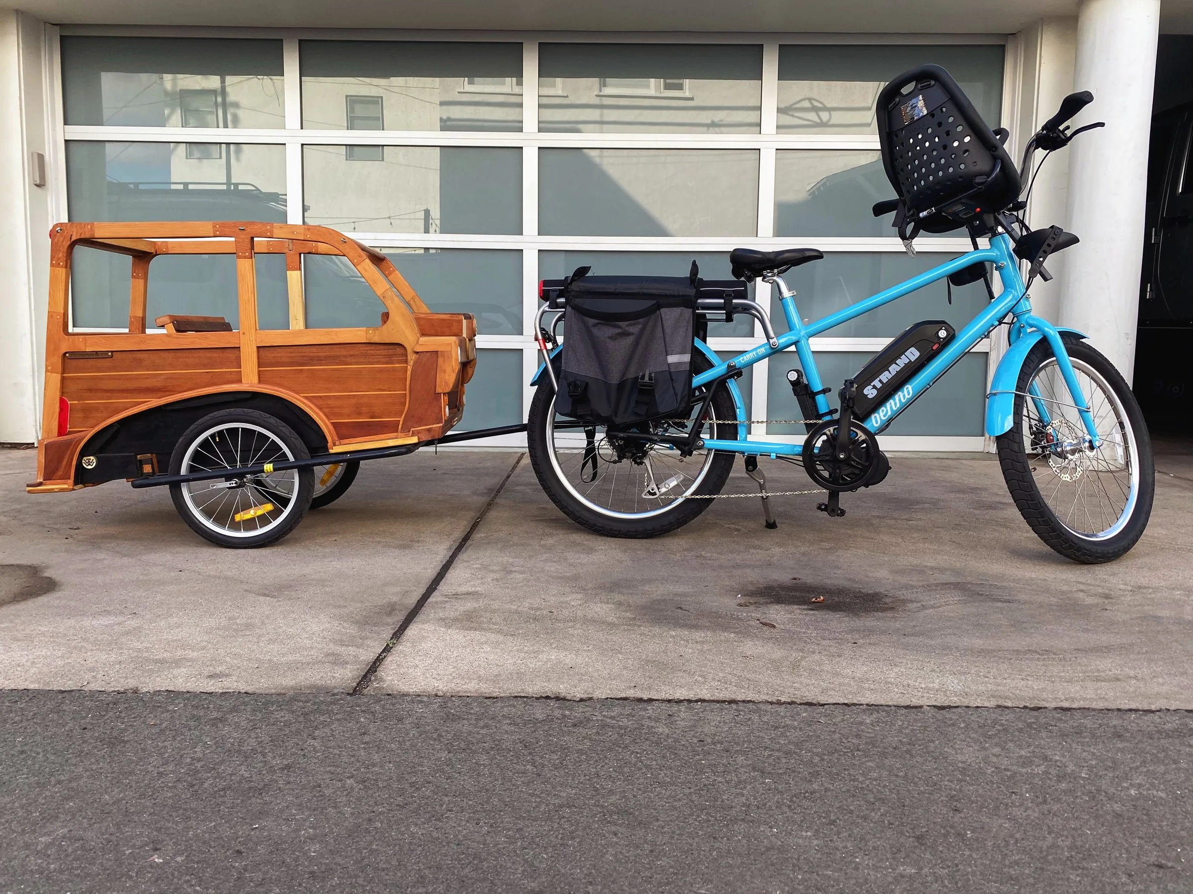Hardwood station-wagon bicycle trailer hitched to a blue cargo bike